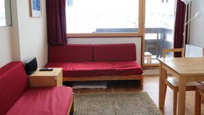 A compact room with a bed, a small desk, a chair, and a table. - Cozy studio 4 pax · Balcony · Wifi · Pets allowed (Tignes)