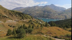 A mountainous landscape with a lake and a road. - Cozy studio 4 pax · Balcony · Wifi · Pets allowed (Tignes)