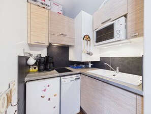 A compact kitchen with a built-in microwave, a dishwasher, and a sink.