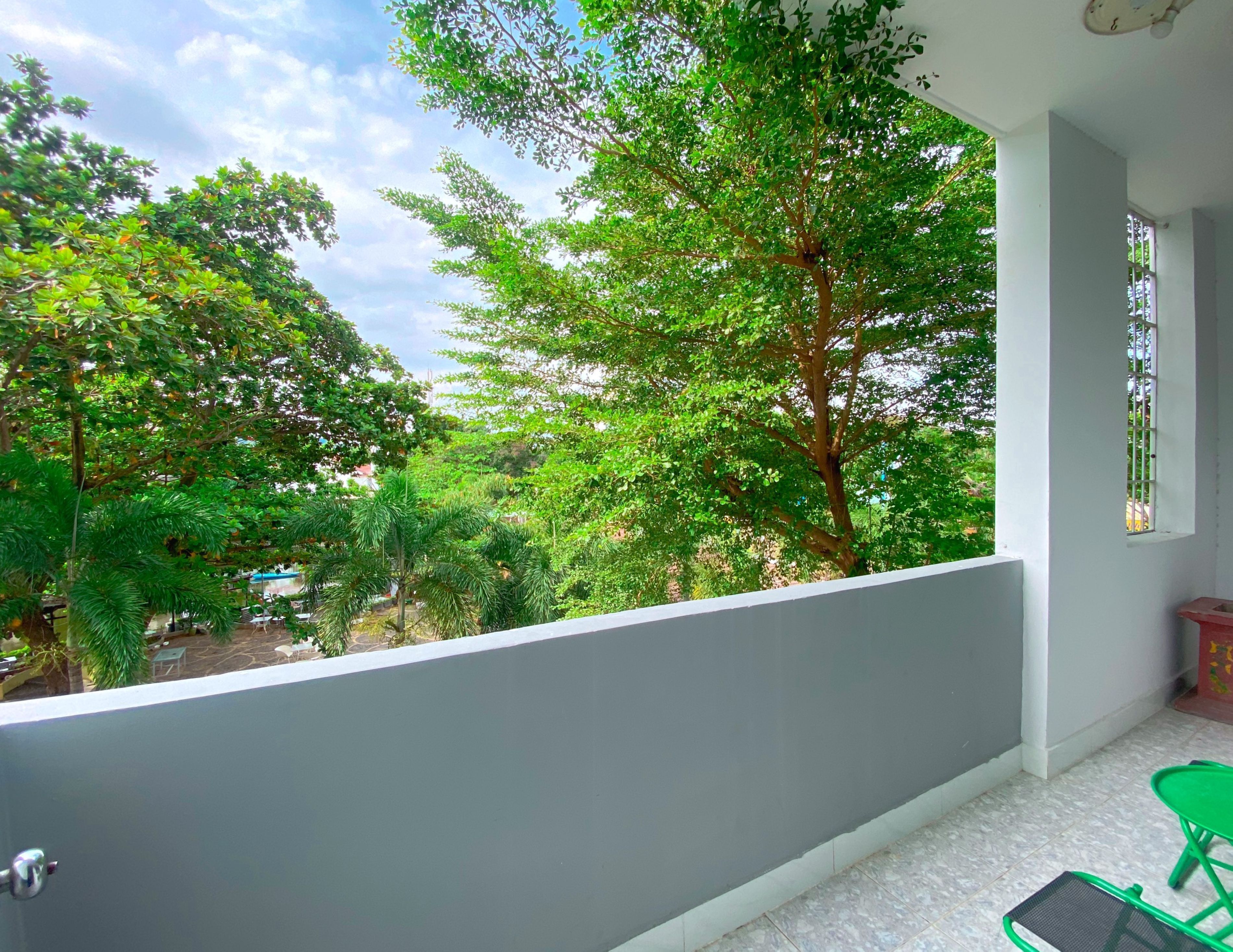 A balcony with a view of lush greenery and trees.