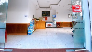 A reception area with a wooden counter, a refrigerator, and a vending machine.