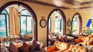 A hotel lobby with seating areas, large windows, and decorative elements. - AL YASMEEN HOTEL (Nablus)