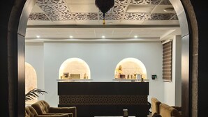 A lobby with a reception desk, two arched seating areas, and a decorative ceiling. - AL YASMEEN HOTEL (Nablus)