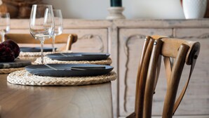 A dining table set with plates, cutlery, and wine glasses. - "Sunset Valley Views" – Close to Beach (Avoca Beach)