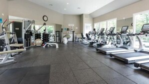 Une salle de sport équipée de tapis de course, de vélos elliptiques et de matériel de musculation.