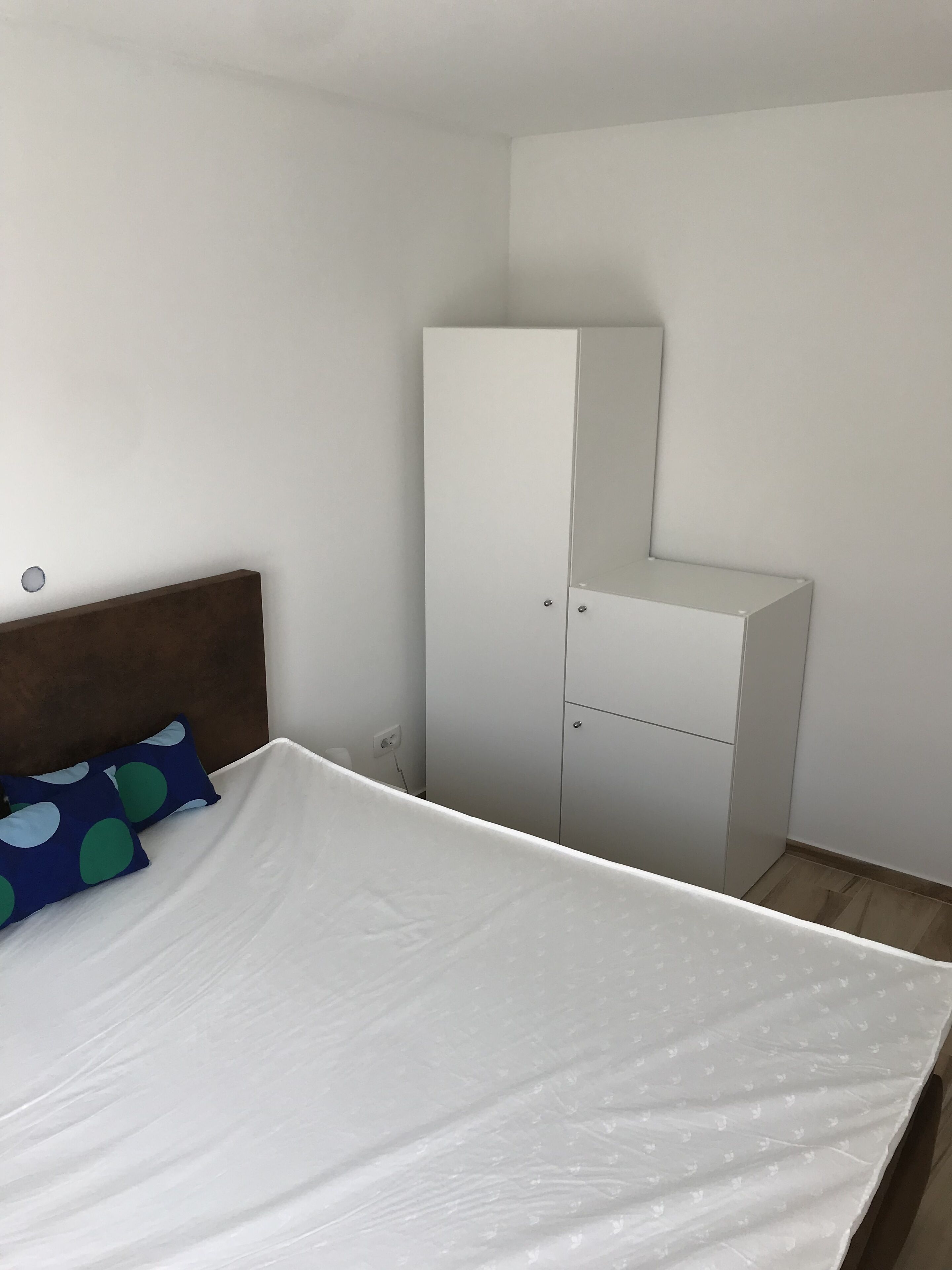 Ein Schlafzimmer mit einem Bett, einem Kleiderschrank und einem Nachttisch.