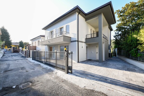 A modern two-story residential building with a balcony on the upper floor.