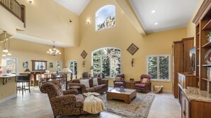 A spacious living room with a high ceiling, large windows, and a cozy fireplace. - Spacious Retreat | Incredible Views & Outdoor Space | Close to Town (Ouray)