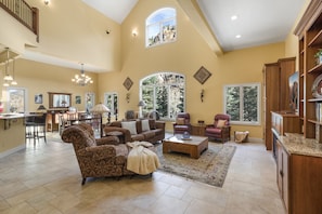 A spacious living room with a high ceiling, large windows, and a cozy fireplace. - Spacious Retreat | Incredible Views & Outdoor Space | Close to Town (Ouray)