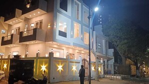 Hotel de diversos pisos amb balcons, façana ben il·luminada i entrada tancada per una reixa.