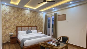 Habitació d'hotel amb llit, taulella de nit i taula petita de menjador amb cadires.