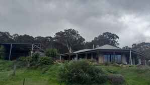 Une maison à deux étages, dot ée d’un porche couvert et d’une antenne parabolique sur le toit.