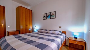 A bedroom with a large bed, wooden wardrobe, bedside tables, and wall art. - Happy Guest Apartments Mountain Panorama Borno (BORNO)