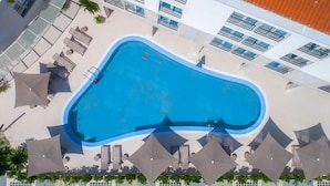 An aerial view of a swimming pool surrounded by lounge chairs and umbrellas, with a building in the background. - Domus Lauri Palace Resort terrace 4 perosons (Umag)