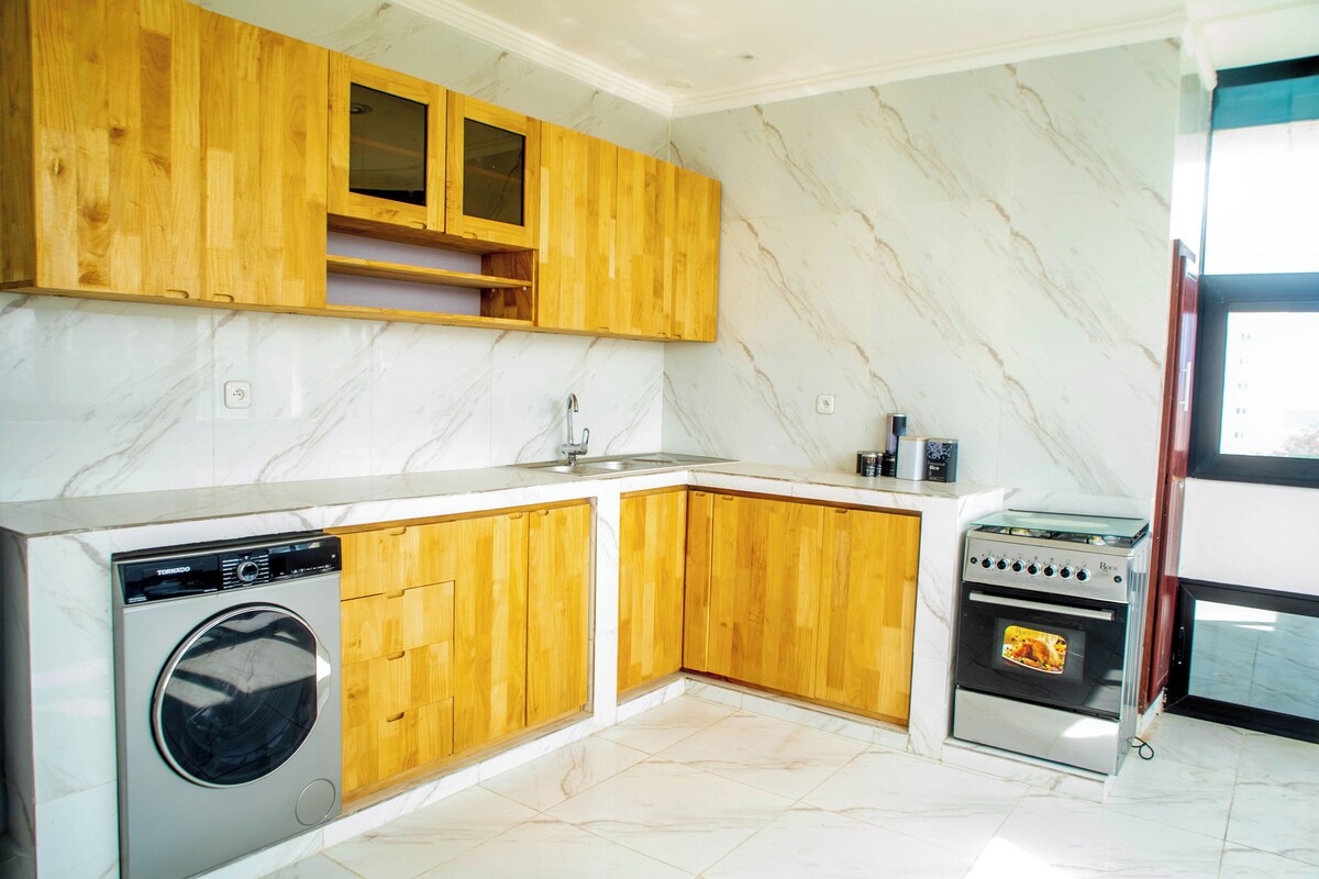 Una cocina con armarios de madera, lavadora y horno.