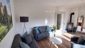 A modern living room with a grey sofa, a white coffee table, and a fireplace.