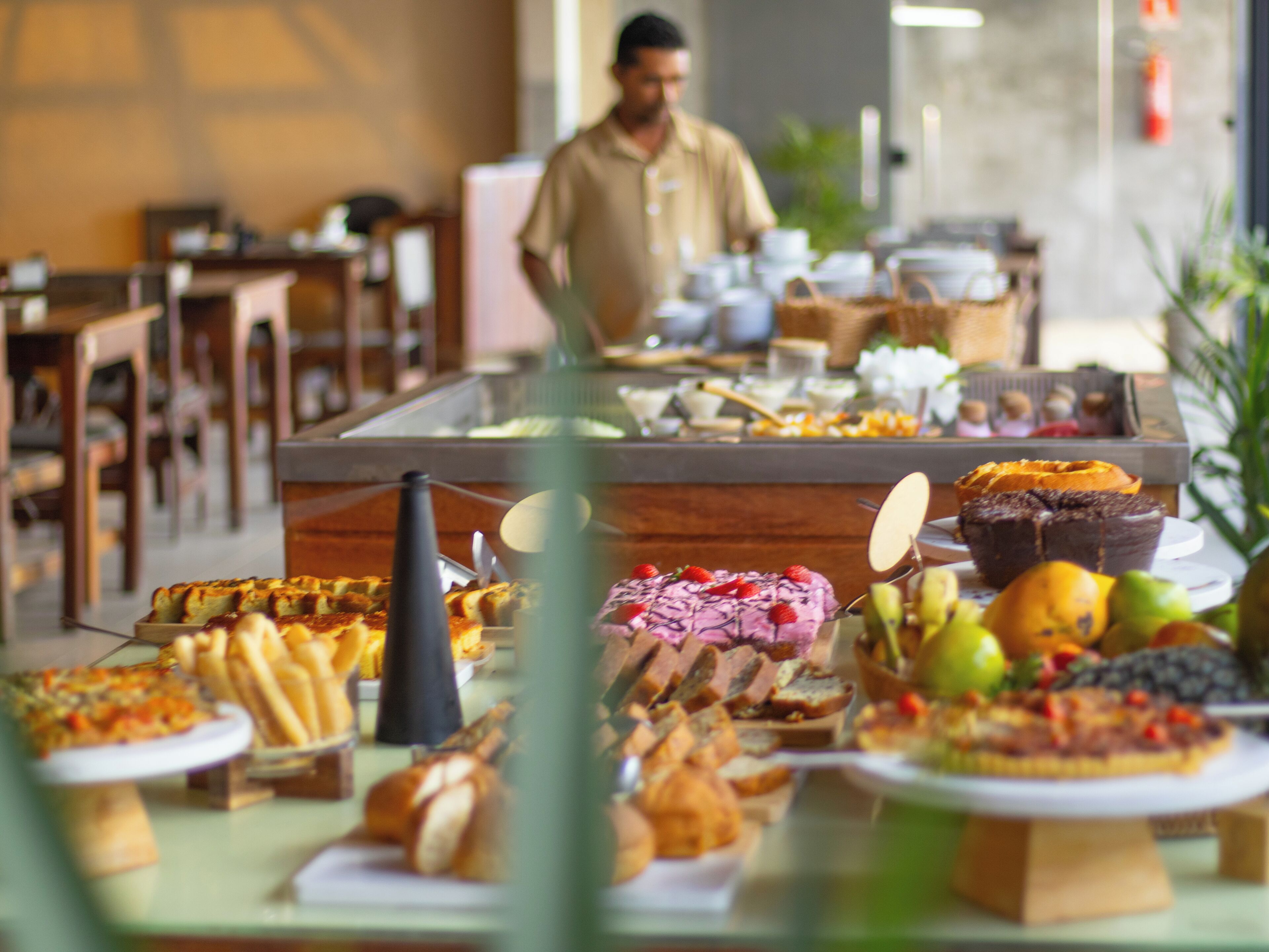 A buffet with various food items and a person in the background.
