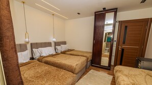 A hotel room with three beds, a wooden door, and a mirror reflecting the bathroom. - White Pyramids inn  (Giza)