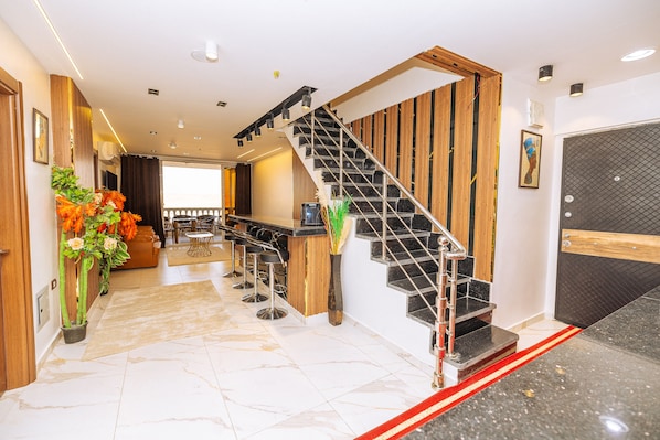 A hotel lobby with a marble floor, a staircase, a reception desk, and a bar area. - White Pyramids inn  (Giza)