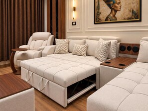 Un salon moderne avec un canapé, un fauteuil inclinable et une table basse en bois.