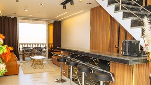 A modern kitchen with a bar area, wooden accents, and a staircase.