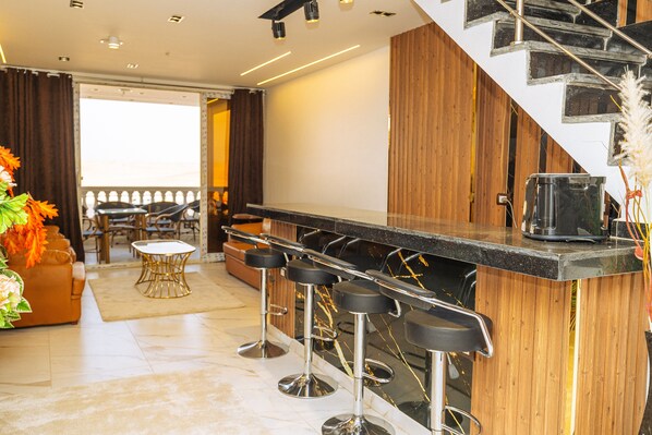 A modern kitchen with a bar area, wooden accents, and a staircase. - White Pyramids inn  (Giza)