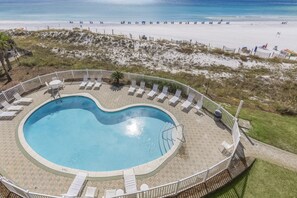 A pool with lounge chairs and a view of the beach. - New Specials - Windancer 404 - Gulf Front, Free Beach Service & Pool (Miramar Beach)
