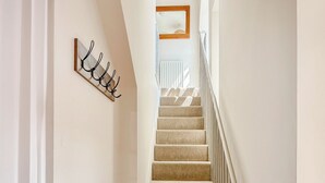 A staircase with beige carpeted steps and a white railing. - The Police Station - UK45642 (Silloth)