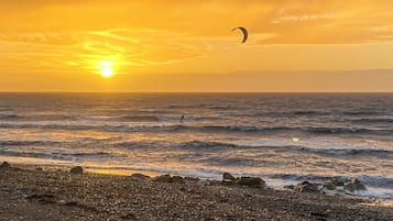 Uma praia com ondas e um pôr do sol.
