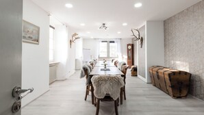 A spacious dining area with a long wooden table, multiple chairs, and a fur-covered bench. - Eventlocation & Hotel Schloss Neuburg (Obrigheim)