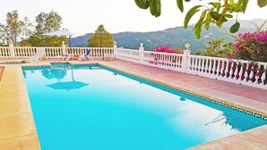 Une piscine rectangulaire, dotée d’une balustrade blanche et entourée d’une terrasse carrelée.