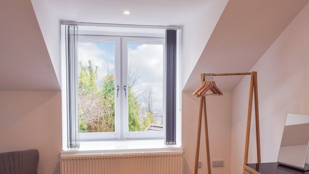 A room with a large window, a radiator, a wooden hanger, and a chair. - 3 bedroom accommodation in Dunoon (Dunoon)