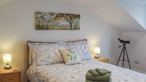 A bedroom with a bed, two bedside lamps, a telescope, and a painting on the wall. - 3 bedroom accommodation in Dunoon (Dunoon)
