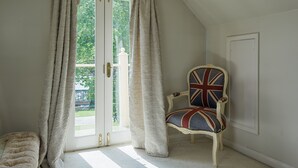 Et værelse med et stort vindue, en stol med Union Jack-design og en hvid dør.