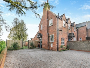 A two-story brick house with a gravel driveway and a wooden fence. - 3 bedroom accommodation in Beverley (Beverley)