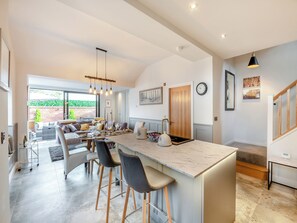 A spacious kitchen with a large island, bar stools, and a dining area with a sofa and table set up. - 3 bedroom accommodation in Beverley (Beverley)