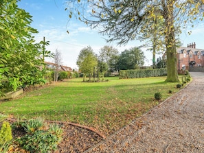A well-maintained garden with a variety of plants and trees, a gravel path, and a brick border. - 3 bedroom accommodation in Beverley (Beverley)