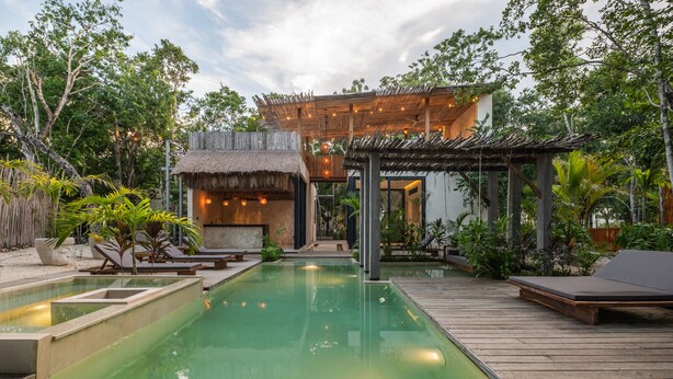 A pool area with a wooden deck, lounge chairs, and a thatched-roof structure. - Villa Tovar Tulum / Private Pool/ Starlink Wi-Fi / Mayan Jungle.  (Tulum)