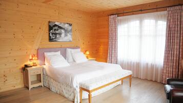 A wooden-paneled bedroom with a bed, nightstands, and a lamp.