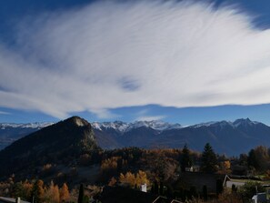 A mountainous landscape with a church and residential buildings. - Between Boutique Hotel (Chamoson)