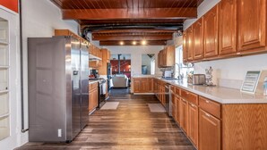 A modern kitchen with wooden cabinets, stainless steel appliances, and a herringbone wood floor. - New!! Majestic Views, Pool, Sleeps 20+, 2 Mstr BR, close DT Yosemite, Bass Lake  (Oakhurst)