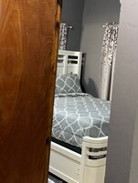 Una camera da letto con un letto, un armadio bianco e un'architrave.