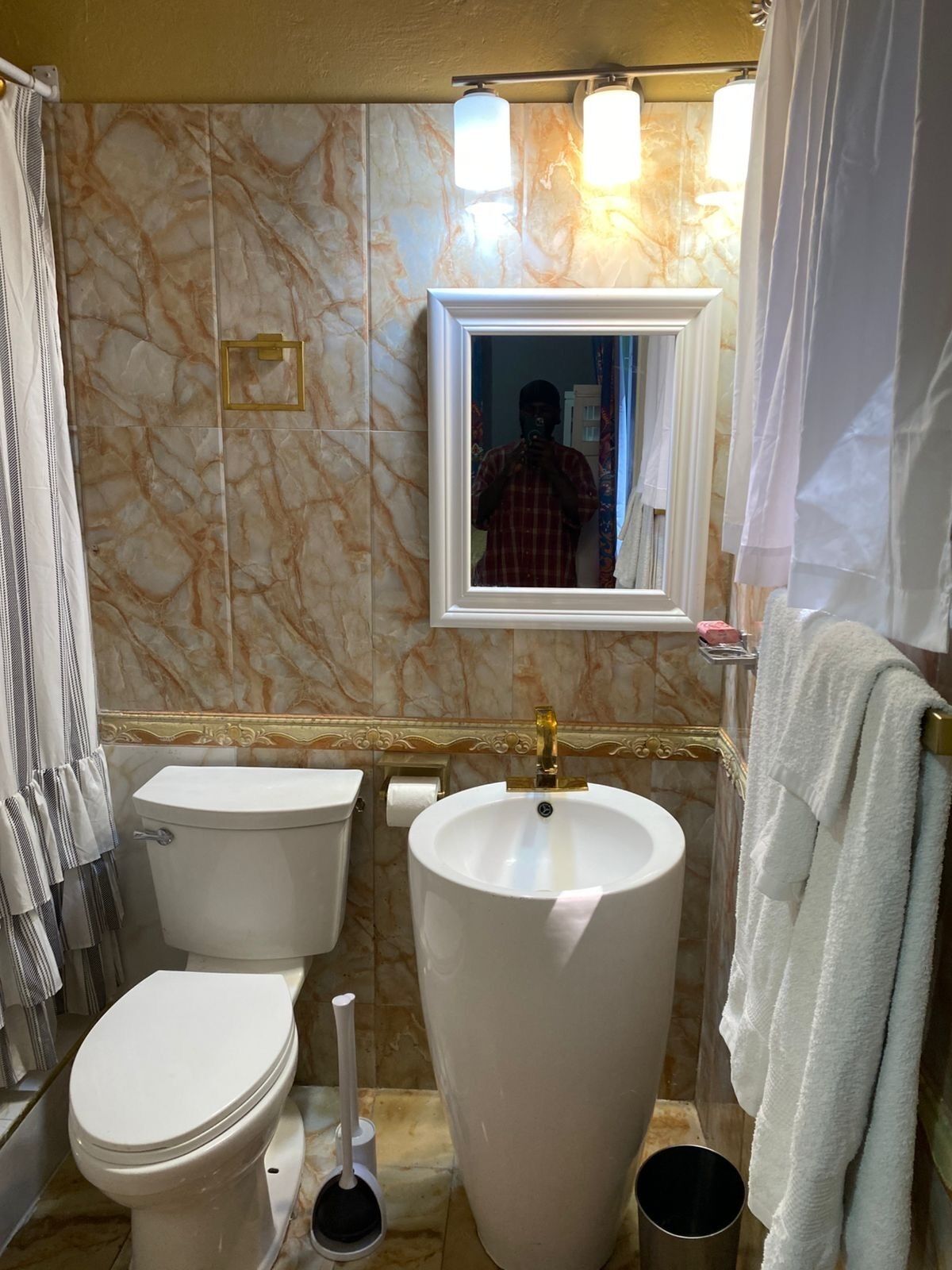 A bathroom with a toilet, sink, and shower area.