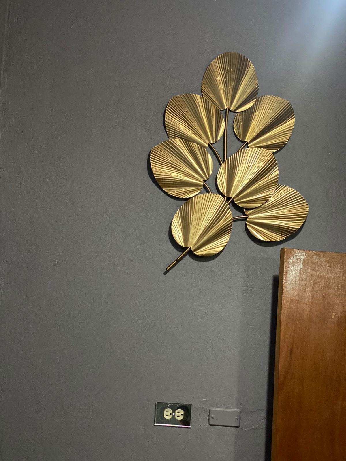 A wall-mounted decorative piece with a leaf-like design.