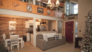 Una sala de estar acogedora con chimenea, comedor y cocina.