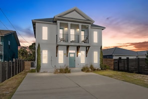 A two-story house with a front porch, a garage, and a driveway. - Heated Pool, Pickeball, Beach House (Panama City Beach)
