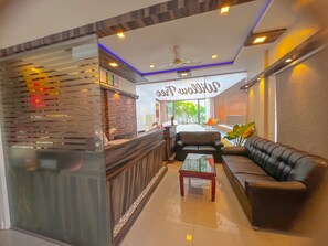 Un hall d’hôtel moderne avec un comptoir d’accueil, un canapé et une table basse.