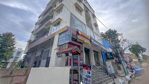 A multi-story building with various commercial establishments, including a business hotel, a mobile zone, and a fast-food restaurant. - Hotel Willow Tree (Bengaluru)