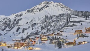 A snow-covered mountain with a ski resort village in the foreground.