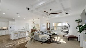 A spacious living area with a large sofa, a coffee table, and a dining area with a bar. - 2 Luxury Homes | Group Retreats | Games | Fire Pit (Round Rock)
